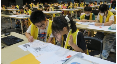 題目公布後，選手們專注閱讀任務說明，討論問題情境與作品設計方向。