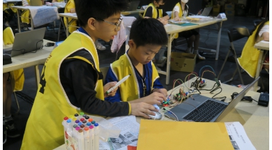 選手們分工合作，一邊檢查程式，一邊測試感測器與接線，讓作品逐步成形。